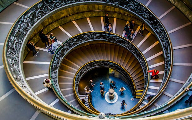 Tourists on the spiral staircase in Vatican Museums, part of the Sistine Chapel tour.