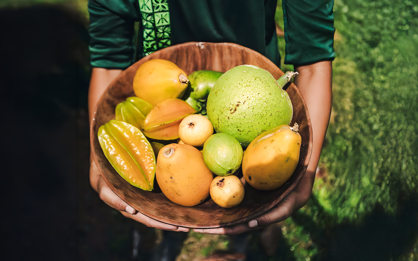 Tropical fruits in a wooden bowl on the Kualoa Grown Tour in Hawaii.