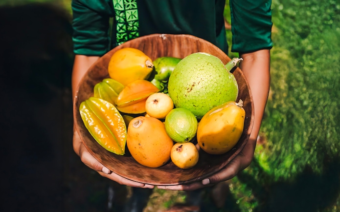 Tropical fruits in a wooden bowl on the Kualoa Grown Tour in Hawaii.
