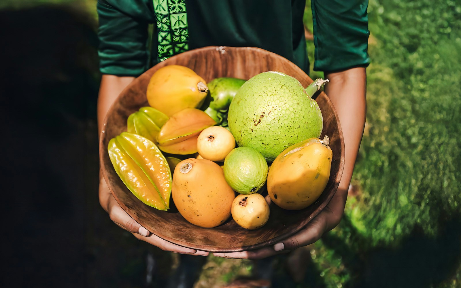Tropical fruits in a wooden bowl on the Kualoa Grown Tour in Hawaii.