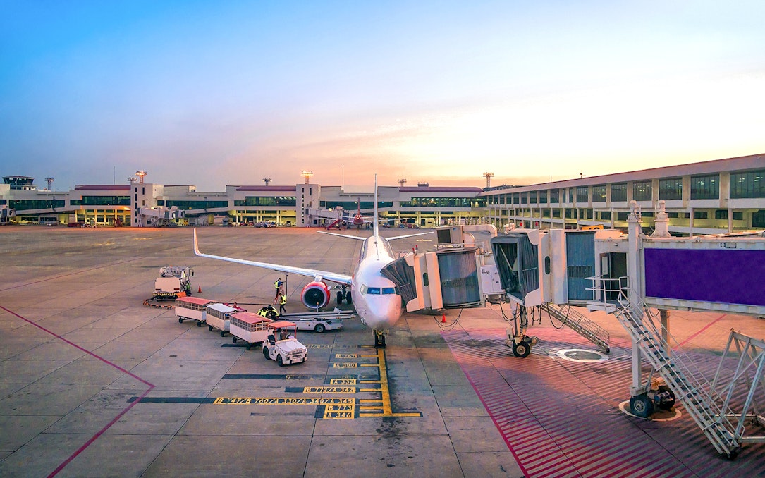 Airplane at gate in Bangkok Suvarnabhumi Airport for private transfer to downtown.