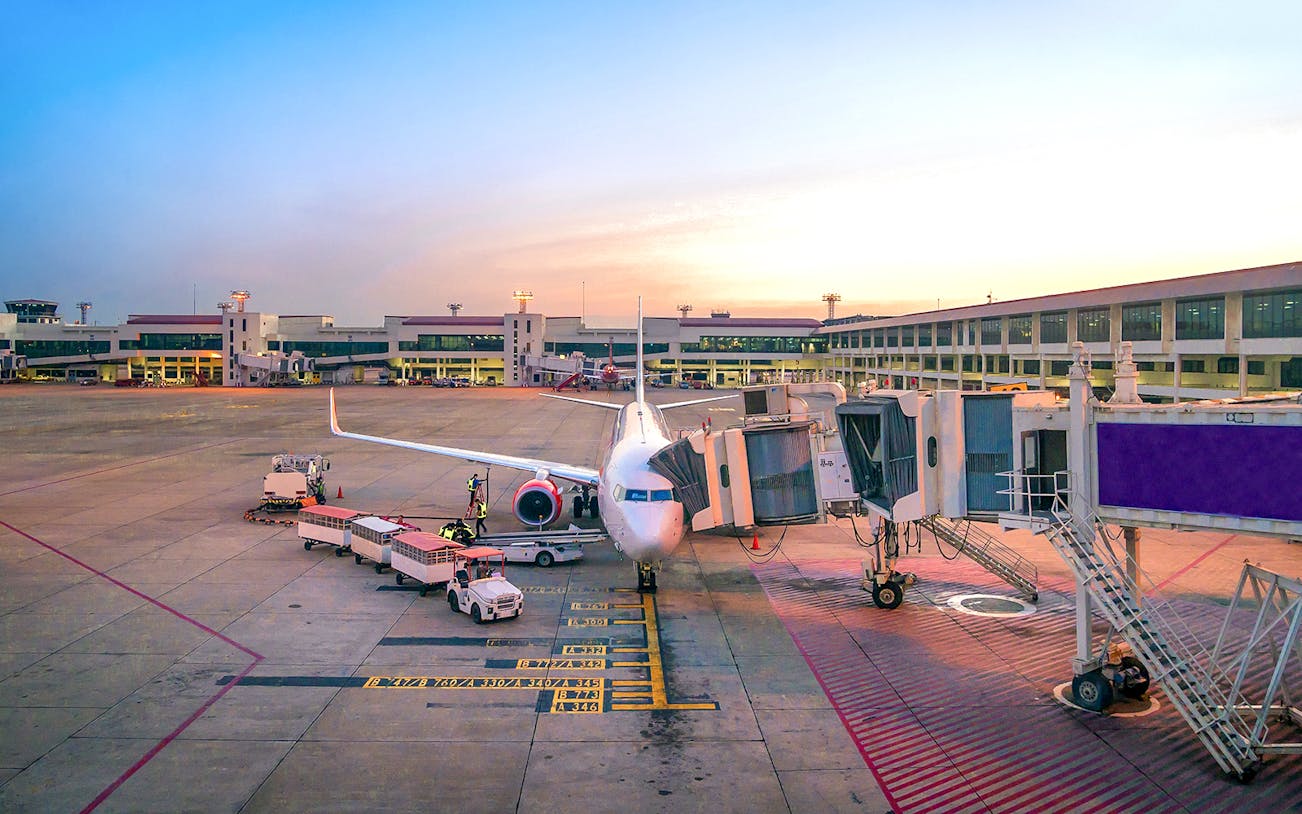 Airplane at gate in Bangkok Suvarnabhumi Airport for private transfer to downtown.
