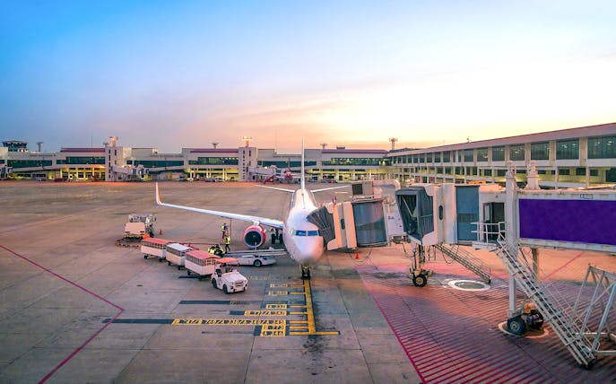 Airplane at gate in Bangkok Suvarnabhumi Airport for private transfer to downtown.
