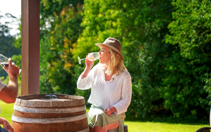 Woman enjoying wine at a winery on a full-day tour, Gold Coast.