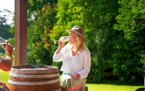 Woman enjoying wine at a winery on a full-day tour, Gold Coast.