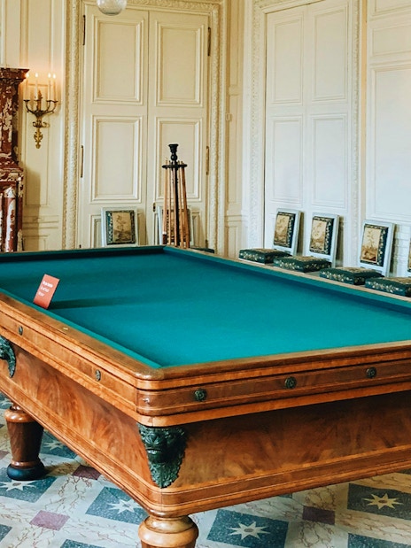 Billiard room with ornate fireplace and decor at the Palace of Versailles.