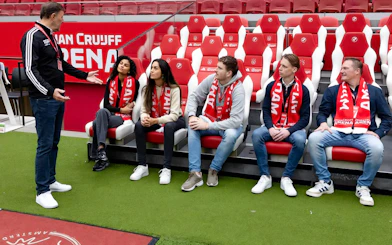 Visitors seated in Johan Cruijff ArenA, Amsterdam, during VIP tour with scarves.