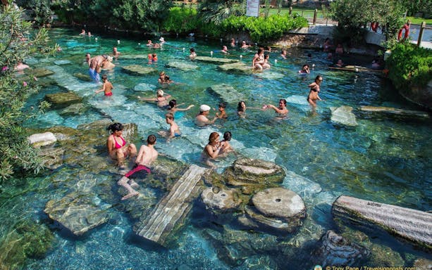 Visitors enjoying thermal pools at Pamukkale, Hierapolis, Antalya day trip.