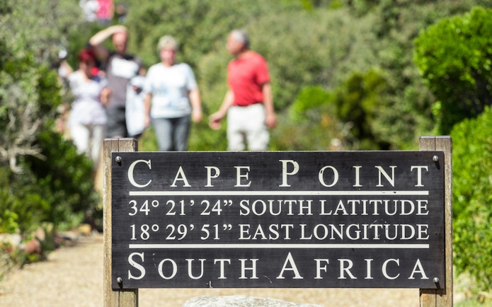 Cape Point sign with coordinates, South Africa pathway in background.