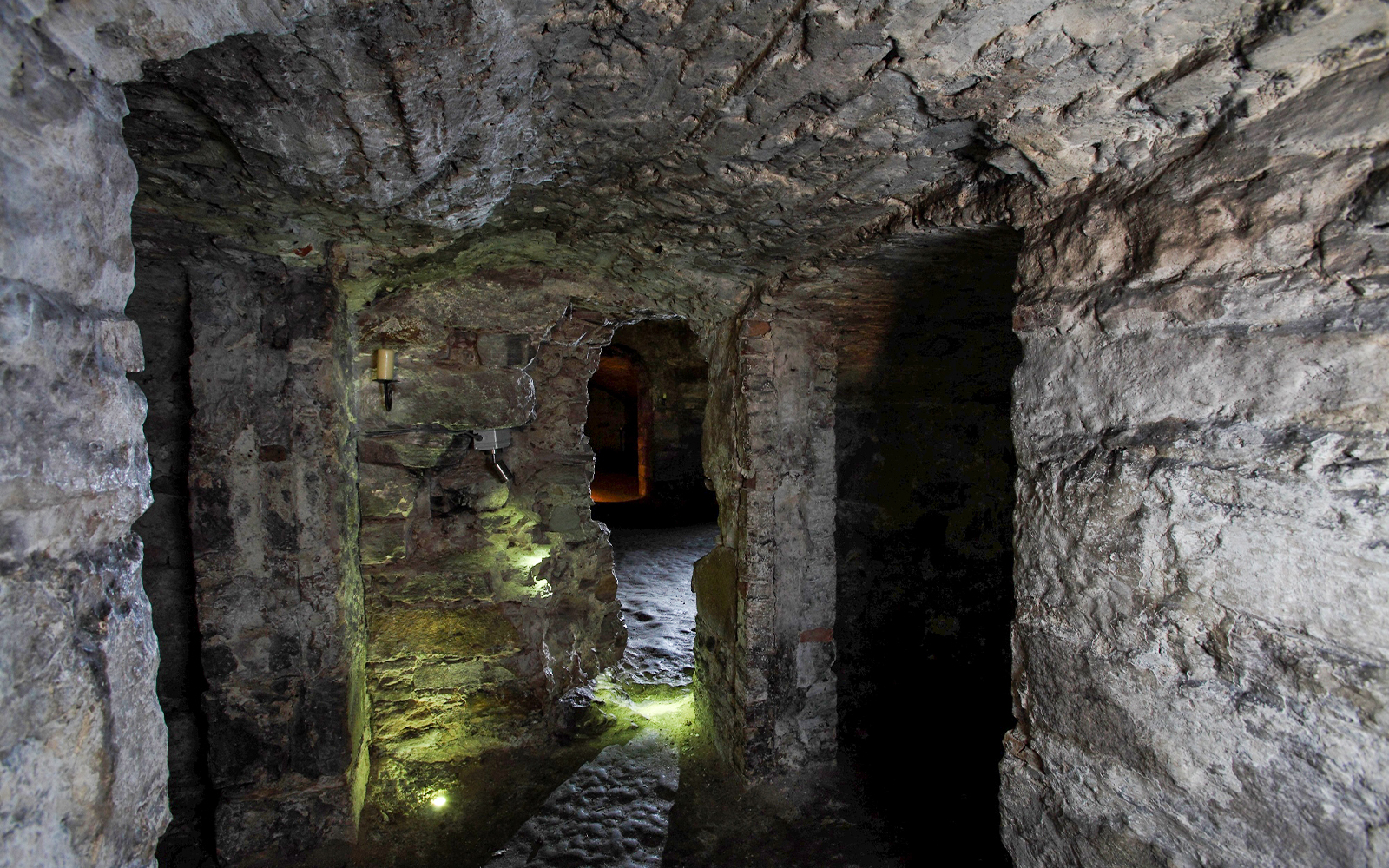 Edinburgh underground vaults with stone walls and dim lighting.