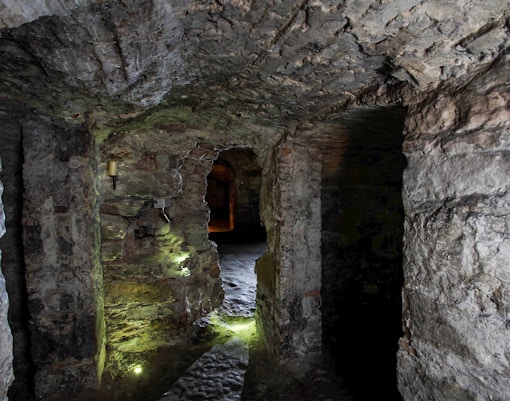 Edinburgh underground vaults with stone walls and dim lighting.