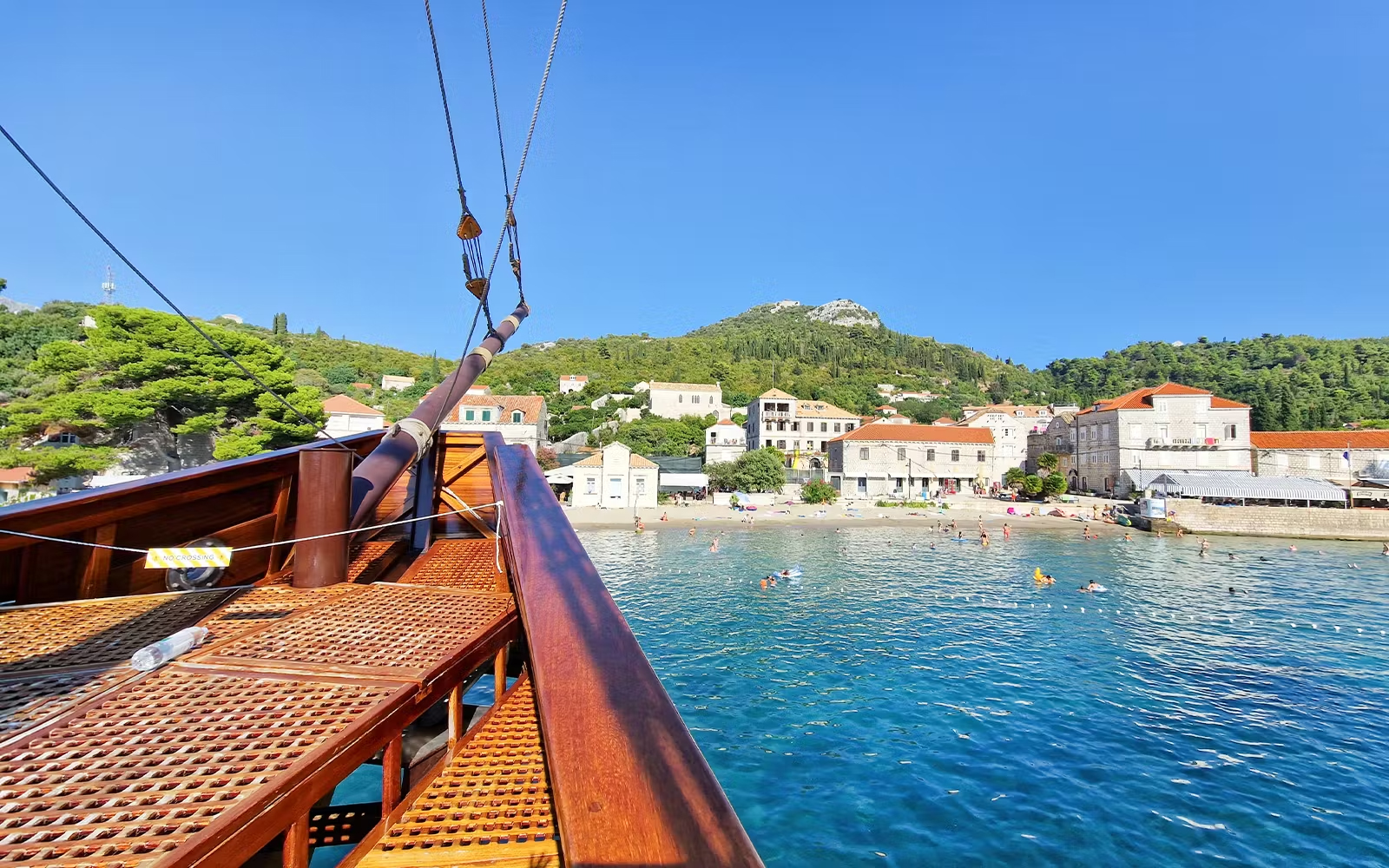 Karaka ship approaching Elaphite Islands with coastal village view.