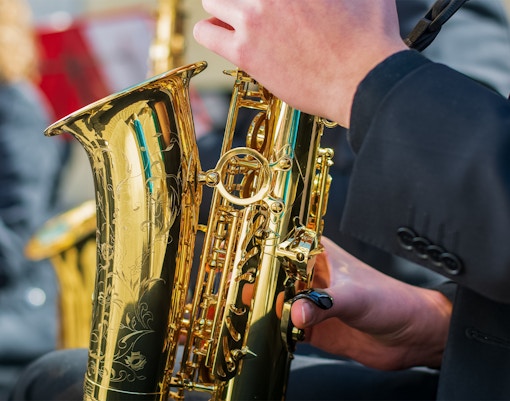 Saxophonist playing on a lively street during Jazz sur Seine Festival