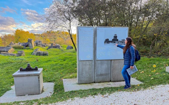 Guide explaining historical site at Plaszow Concentration Camp in Krakow with informational panels.