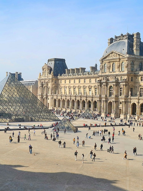 Louvre Museum courtyard with glass pyramid in Paris.