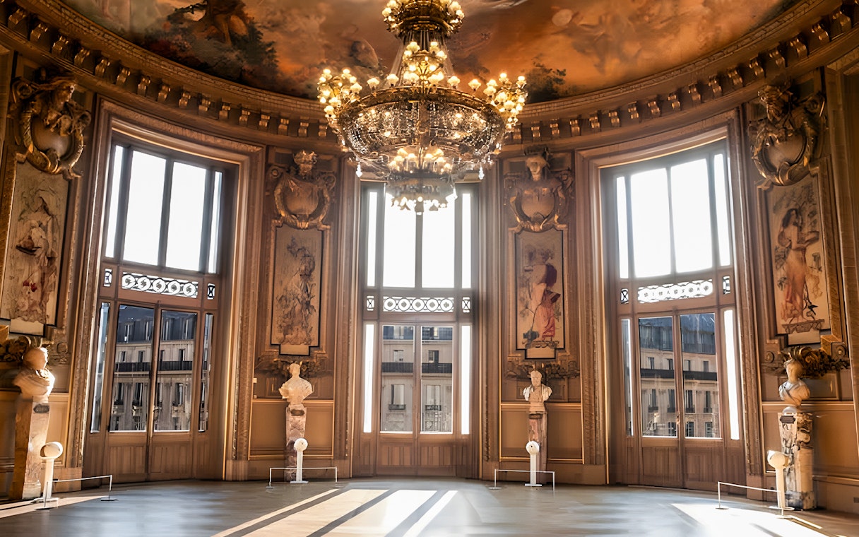 Glacier rotunda with ornate chandelier and statues at Opera Garnier, Paris.