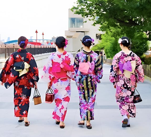 Women in colorful kimonos walking along a path in Tokyo, Japan.