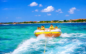 Tubing adventure at Tanjung Benoa, Bali with tourists enjoying ocean watersports.