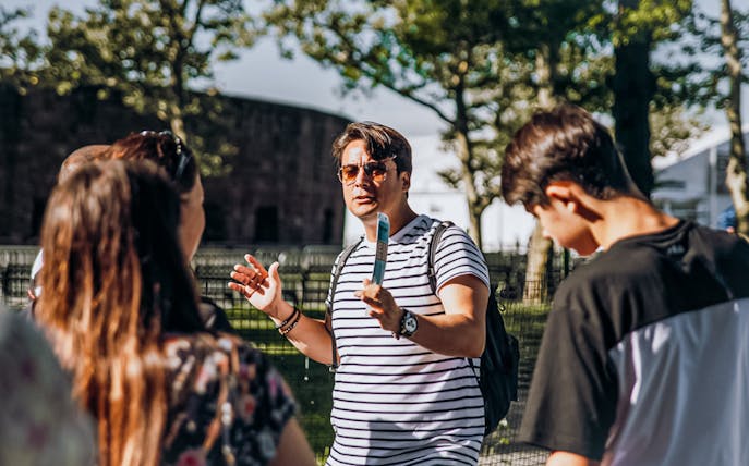 Tour guide explaining to visitors during Statue of Liberty tour with Ellis Island.