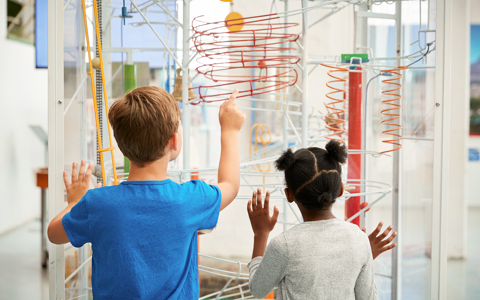 Back view of Two kids looking at a science exhibit