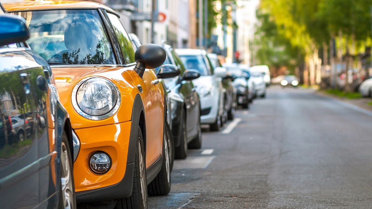 Spacious car parking area with multiple vehicles in a city setting.