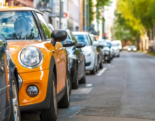 Spacious car parking area with multiple vehicles in a city setting.