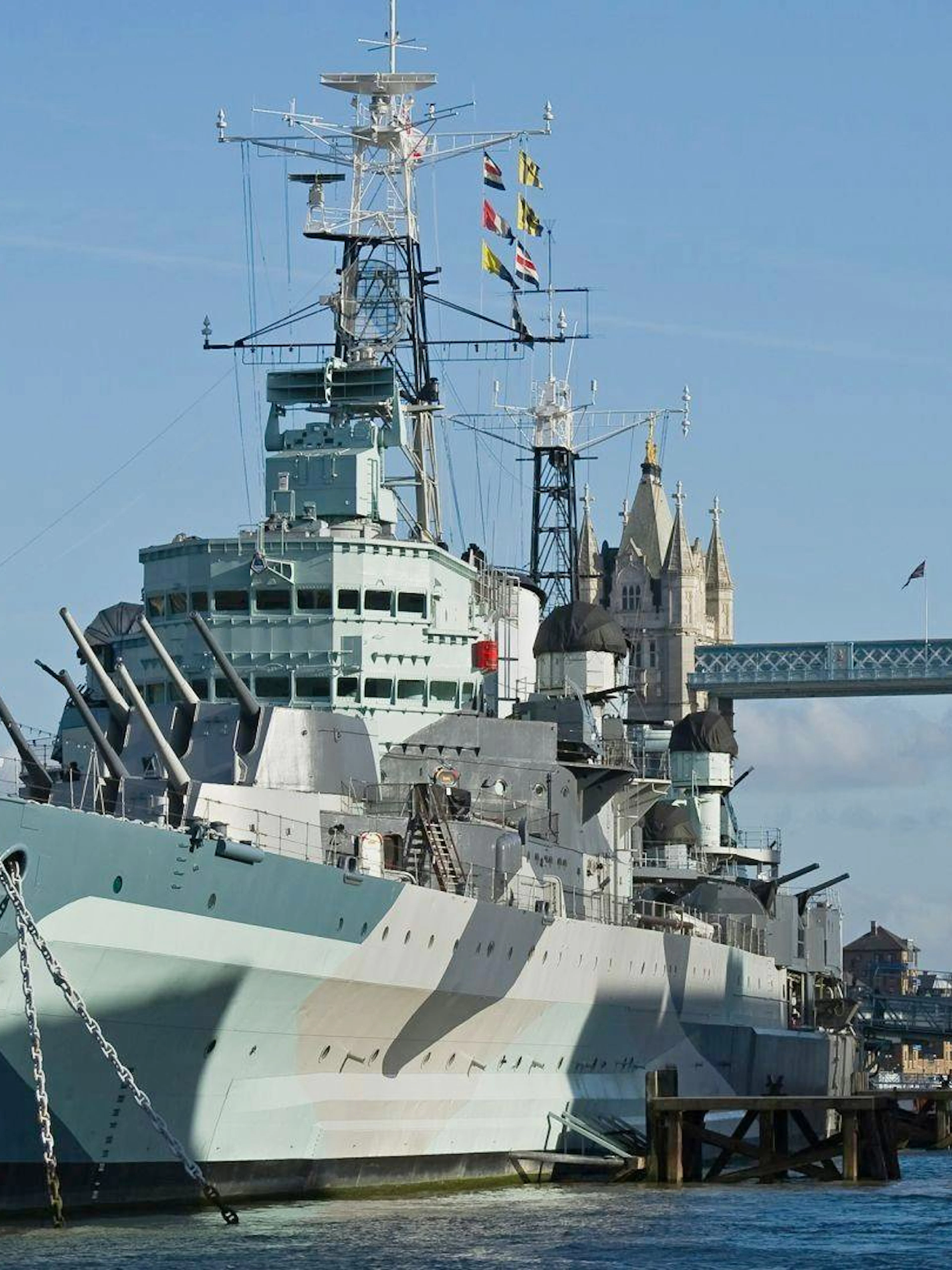 HMS Belfast moored on the River Thames with Tower Bridge in the background, London.