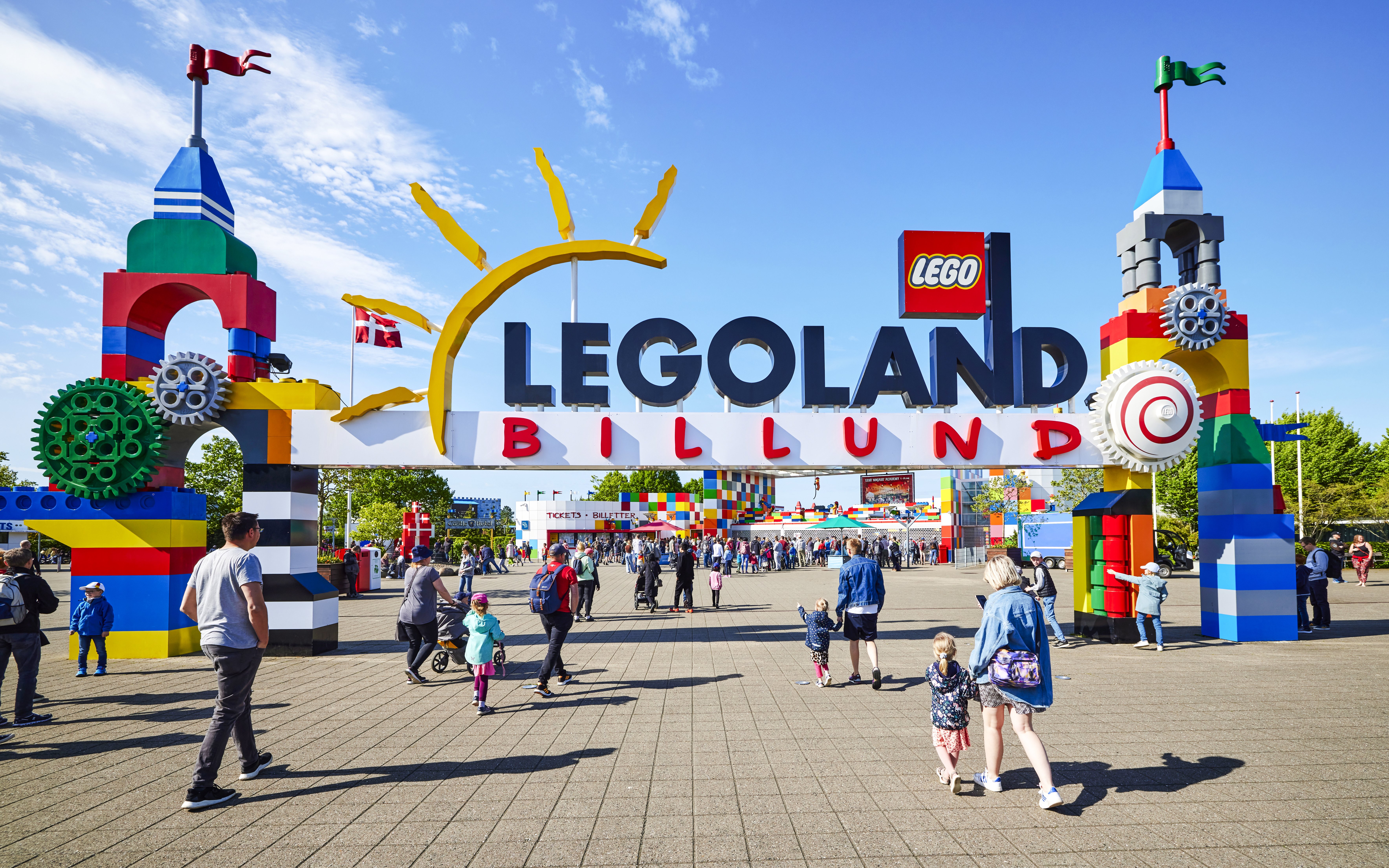 Entrance to LEGOLAND Billund with colorful LEGO structures and visitors walking.