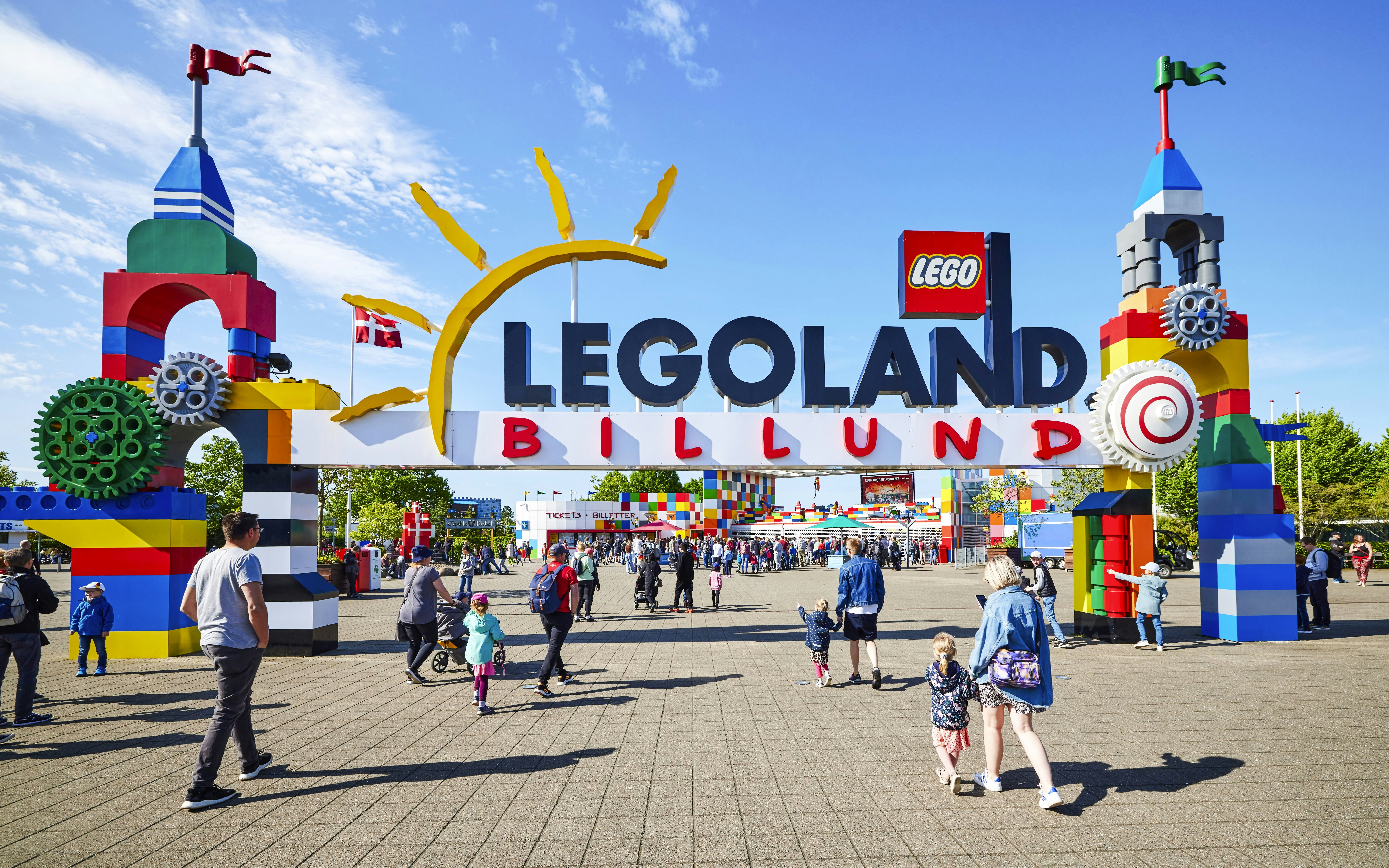 Entrance to LEGOLAND Billund with colorful LEGO structures and visitors walking.