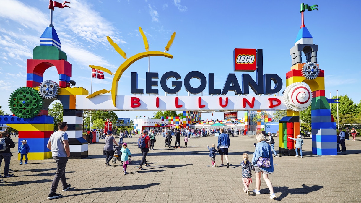 Entrance to LEGOLAND Billund with colorful LEGO structures and visitors walking.