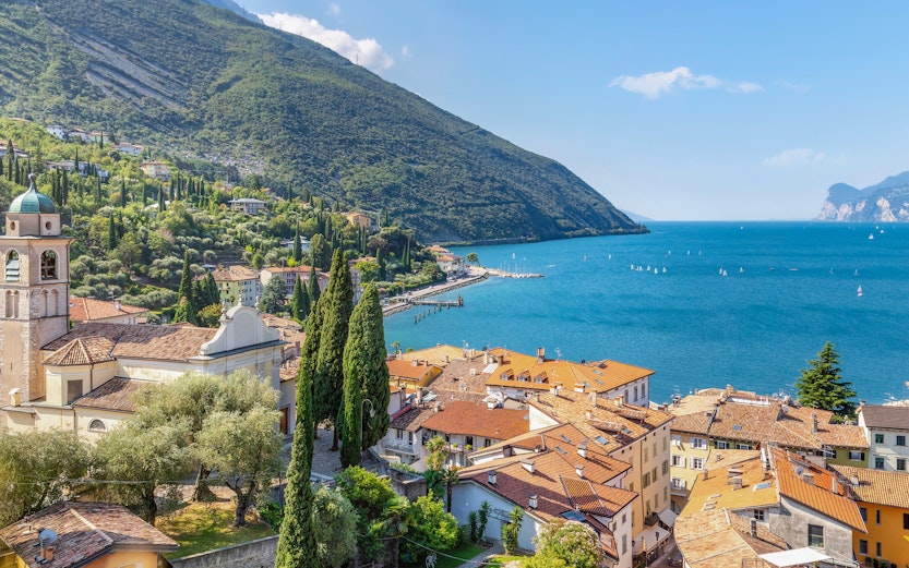 Aerial view of Lake Garda with coastal town and mountains in the background.