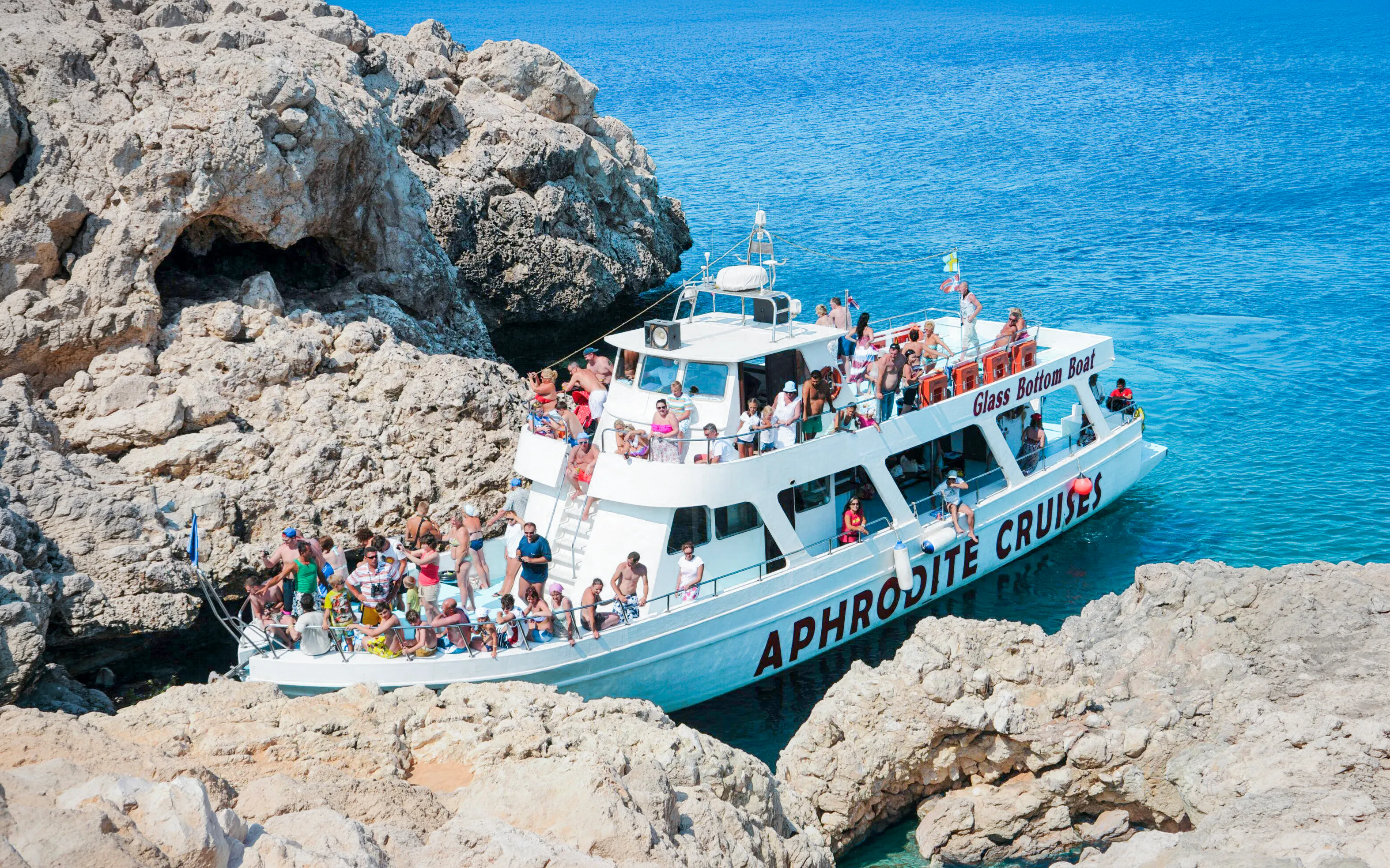 Cruise boat near sea caves with tourists on Blue Lagoon tour from Protaras.