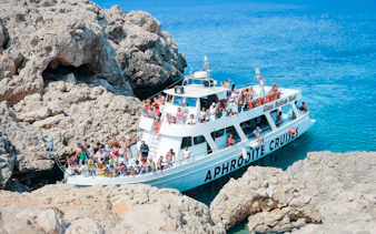 Cruise boat near sea caves with tourists on Blue Lagoon tour from Protaras.