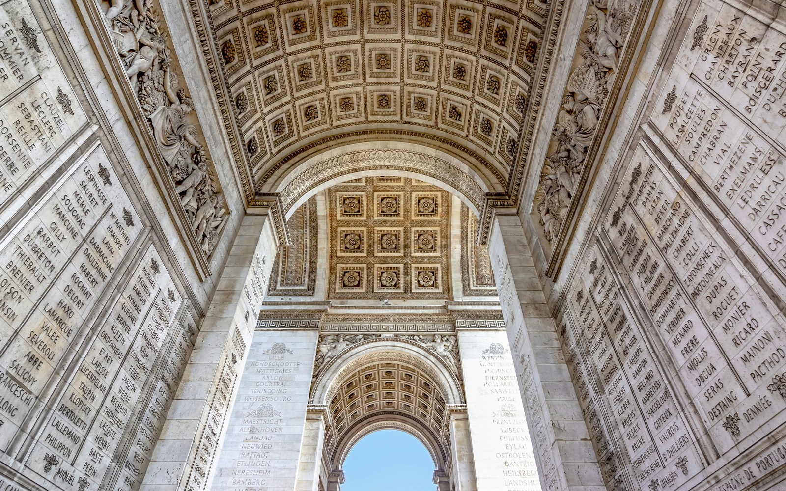 Arc de Triomphe with rooftop view, Paris, showcasing intricate architectural details.