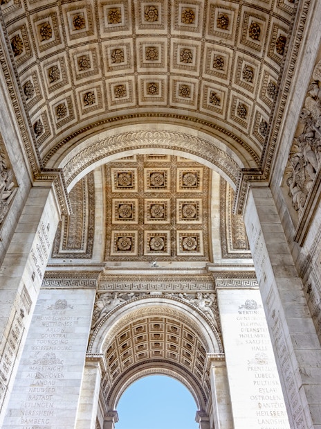 Arc de Triomphe interior with engraved names and ornate ceiling, Paris.