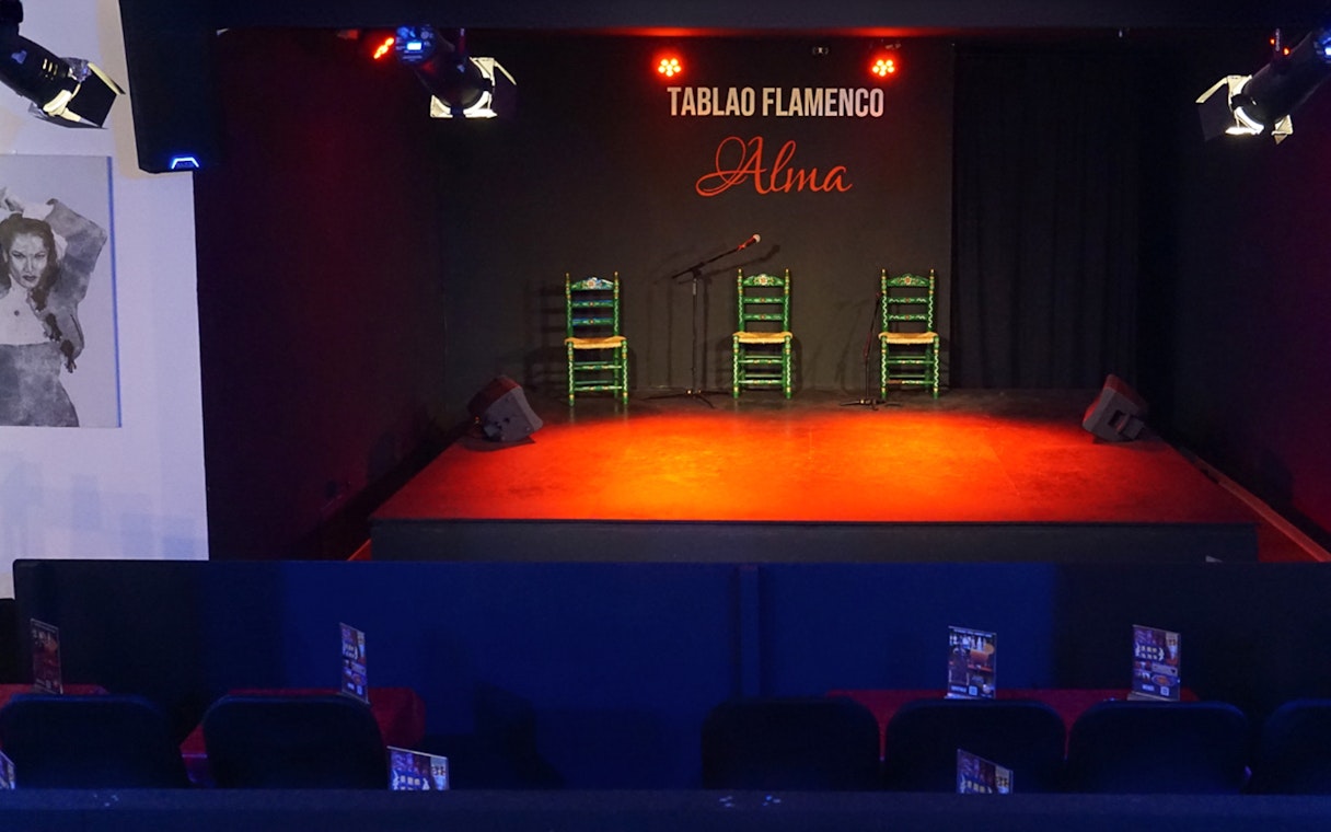 Stage setup for Flamenco Show at Tablao Flamenco Alma with chairs and microphone.
