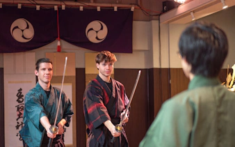 Participants practicing swordplay in traditional attire during Tokyo Samurai Experience.