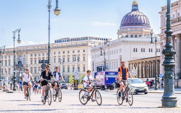 Cyclists on a guided tour in Berlin, passing historic buildings and landmarks.