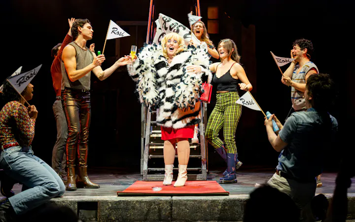Performers on stage during "We Are Alive" show in Berlin, holding flags and celebrating.