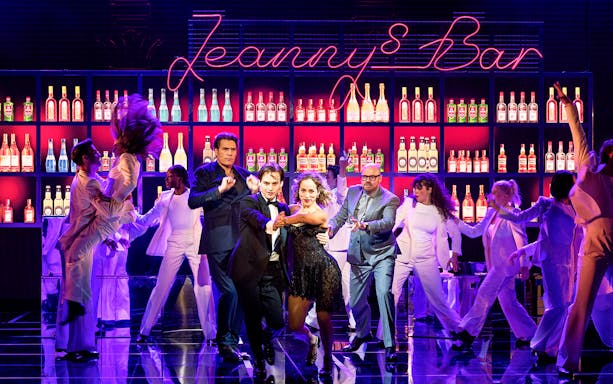 Performers dancing in front of a bar set during Rock Me Amadeus – The Falco Musical in Austria.