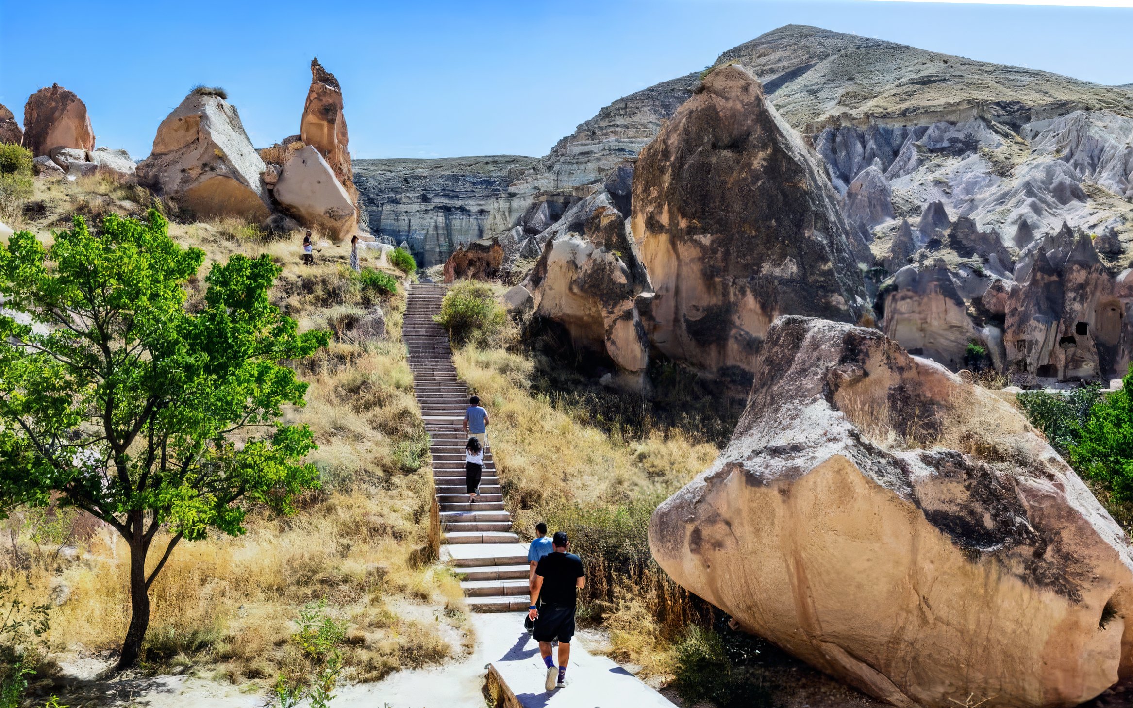 Visitors walking among unique rock formations in Cappadocia, Turkey.