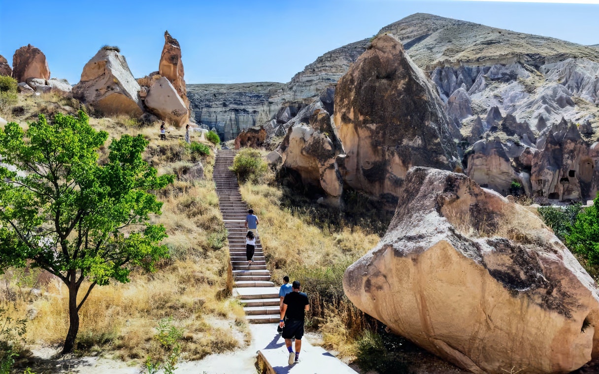 Visitors walking among unique rock formations in Cappadocia, Turkey.