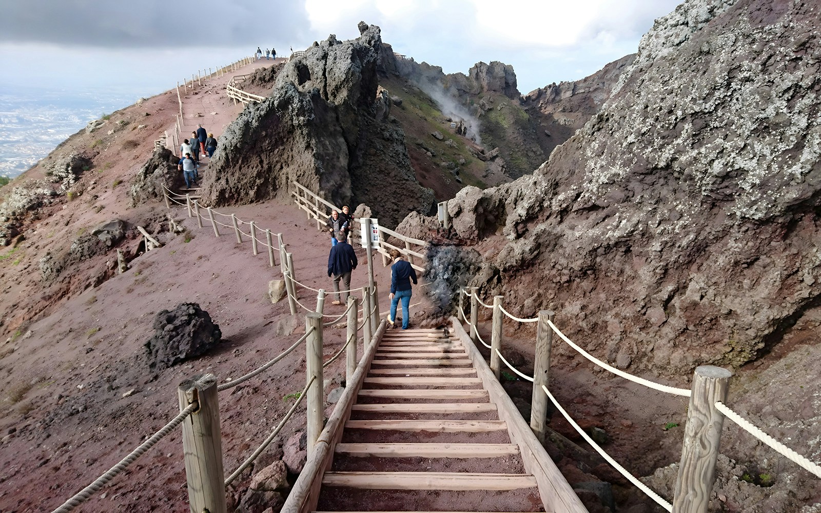 Barricaded staircase ascending Mount Vesuvius, Naples, with scenic volcanic landscape.
