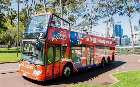 Perth sightseeing bus on tour with city skyline in background.