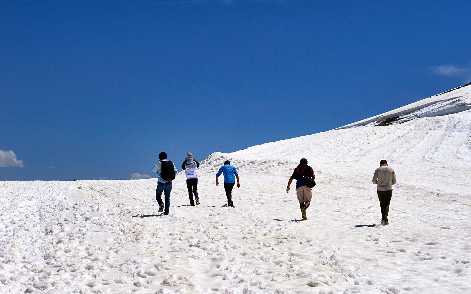Eine Gruppe wandert mit Schneekleidung durch die verschneiten Schweizer Alpen