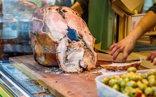 Porchetta being sliced at a street food stall in Rome.