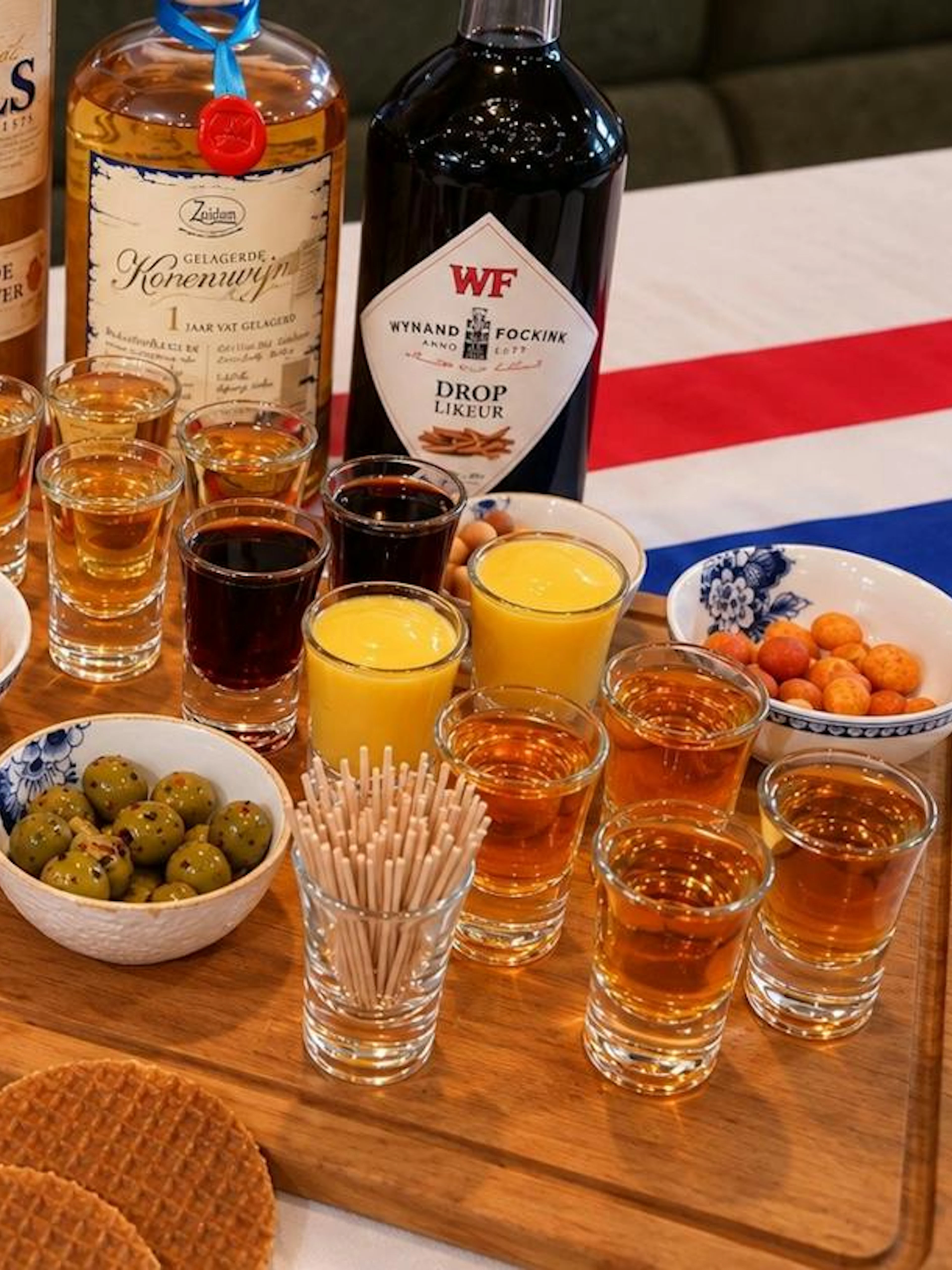Traditional Dutch drinks and snacks, including genever, advocaat, cheese, and stroopwafels, in Amsterdam.