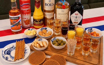 Traditional Dutch drinks and snacks, including genever, advocaat, cheese, and stroopwafels, in Amsterdam.
