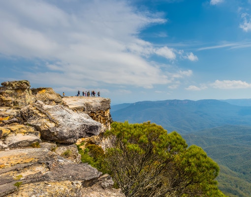 Group at Lincoln's Rock, Blue Mountains, overlooking scenic valley during nature walk.