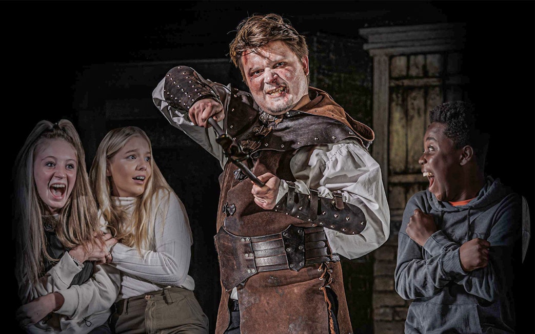 Actor in medieval costume scaring visitors at London Dungeon VIP experience.